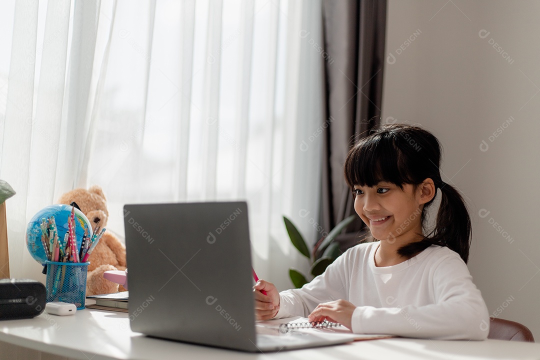 Aluna asiática fazendo sua lição de casa com o laptop em casa