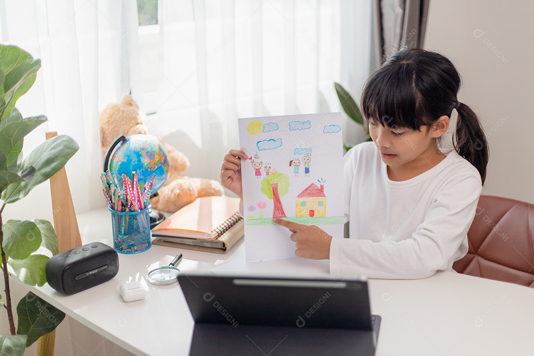 Aluna asiática fazendo sua lição de casa com tablet digital em casa.