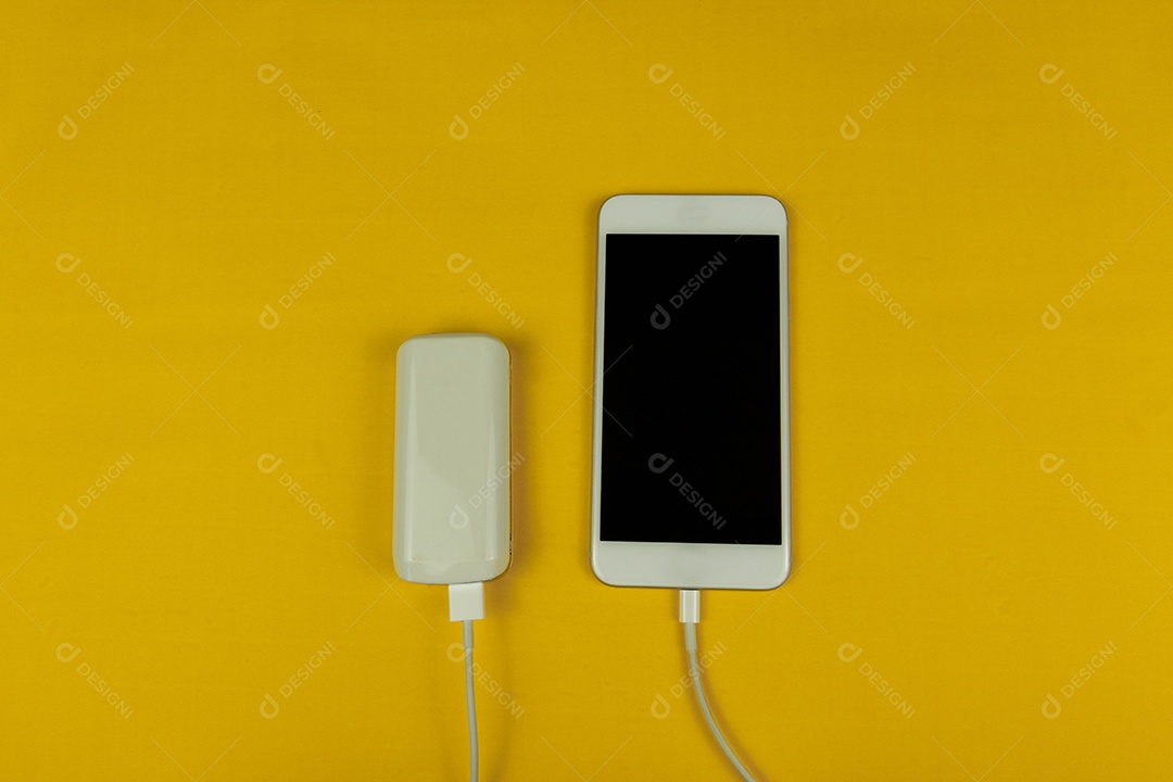 Telefone celular móvel branco e carregador de potência branco sobre fundo amarelo.