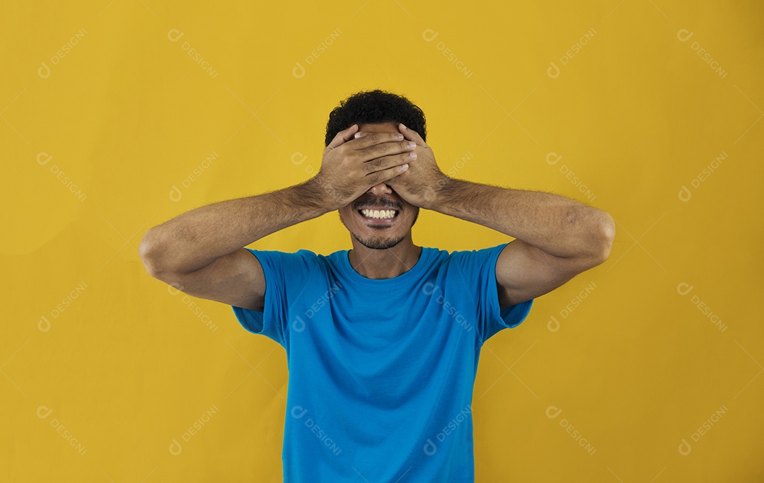 Homem cobrindo os olhos isolados em fundo amarelo