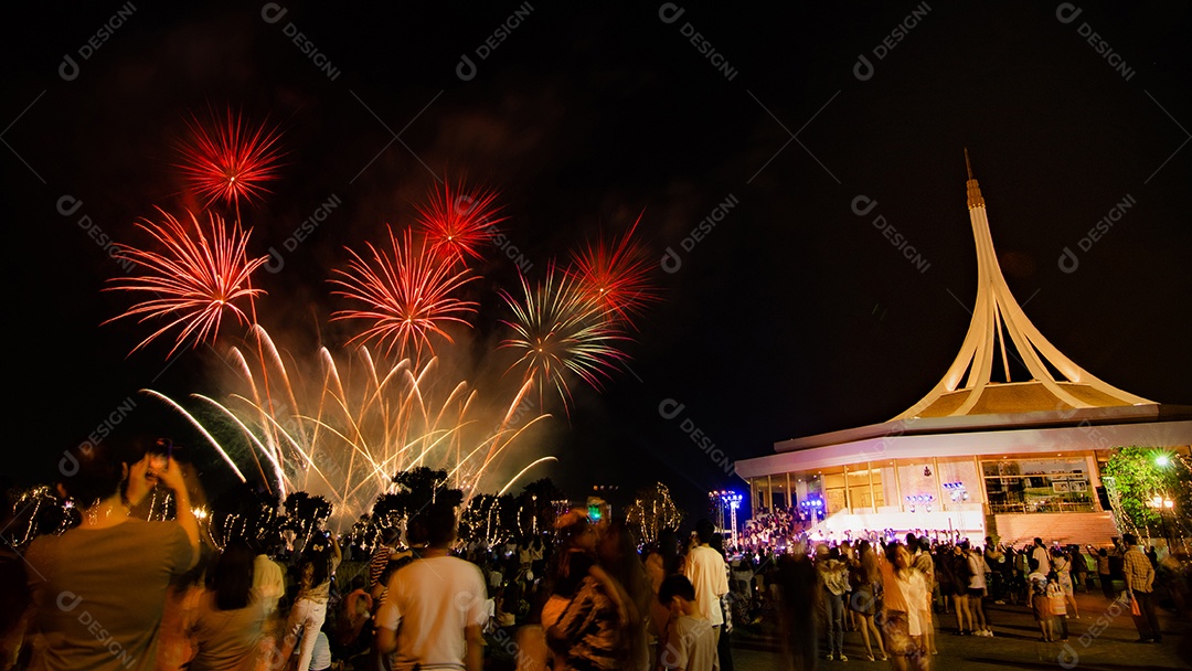 Belos fogos de artifício no parque e pessoas olhando para os fogos