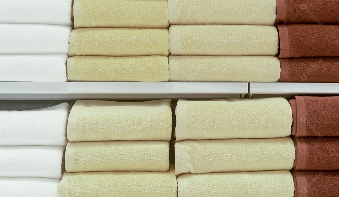 Lindas toalhas de banho coloridas são dobradas ordenadamente nas prateleiras da loja