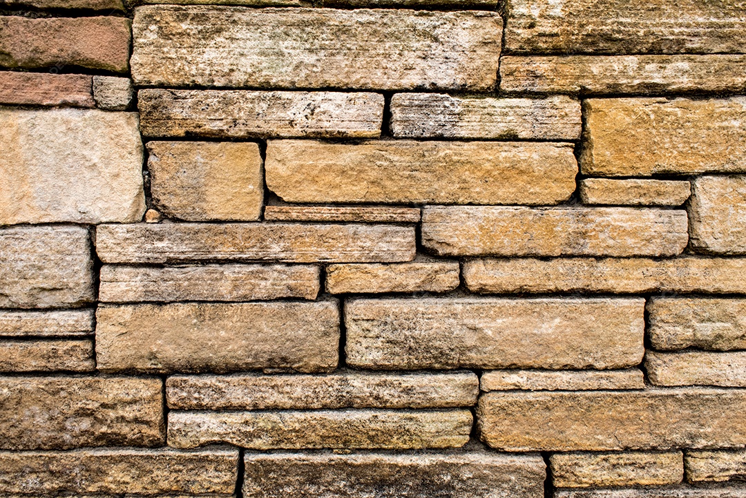 Fundo amarelado da textura da parede de pedra