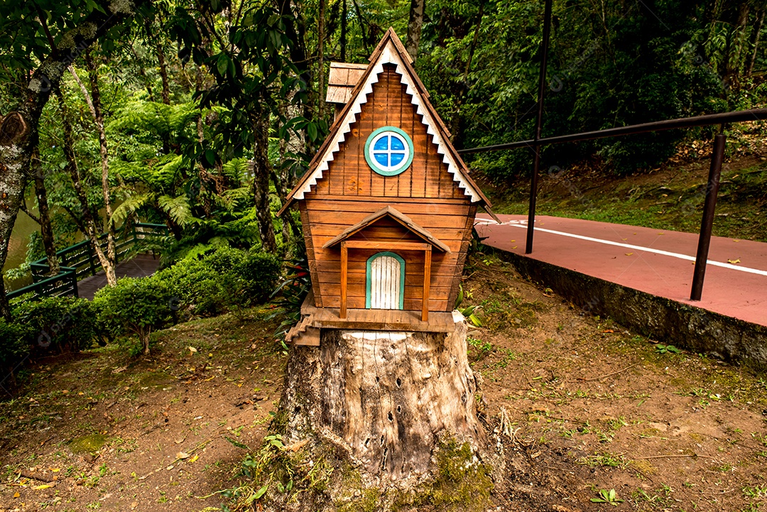 Casa de madeira em miniatura em um tronco de árvore