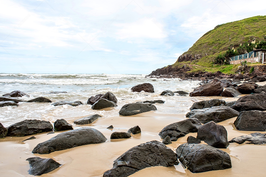 Rocks in the sand and in the South American sea, Torres beach, Rio Gran