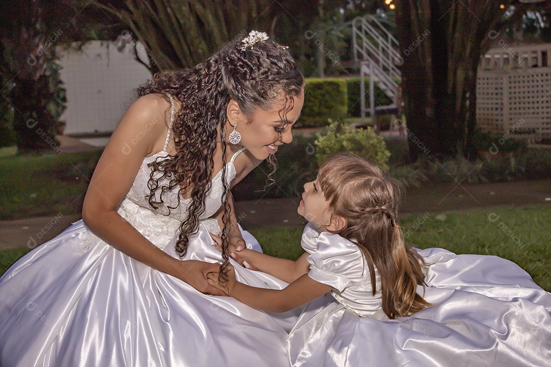 Linda noiva brincando com sua filha sobre festa de casamento