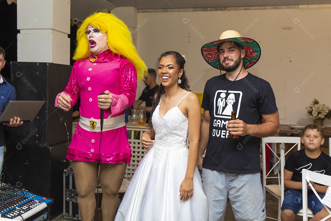 Homem usando chapéu de palha ao lado de uma pessoa fantasiada