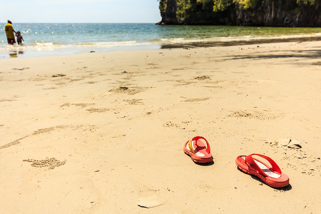 Mãe e filho com sandália na praia no verão em Trang