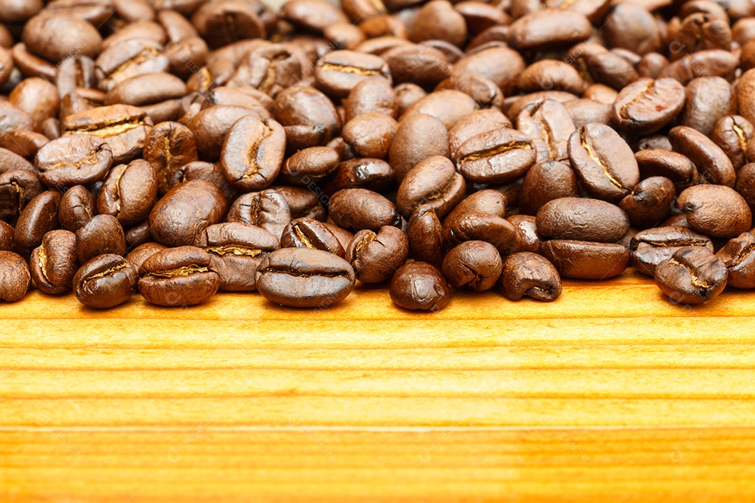 Grãos de café sobre uma mesa de madeira