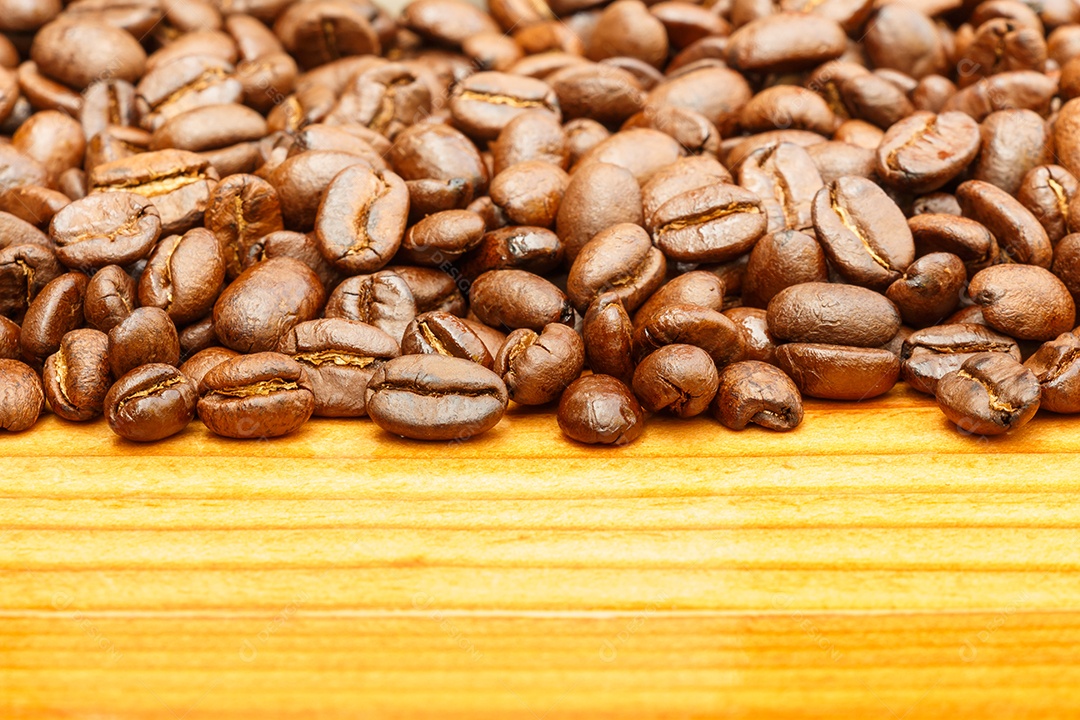 Café torrado sobre uma mesa de madeira amarela