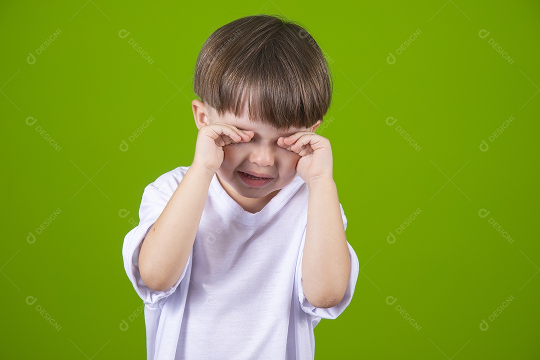 Lindo garotinho feliz e sorridente usando camiseta branca sobre fundo isolado verde