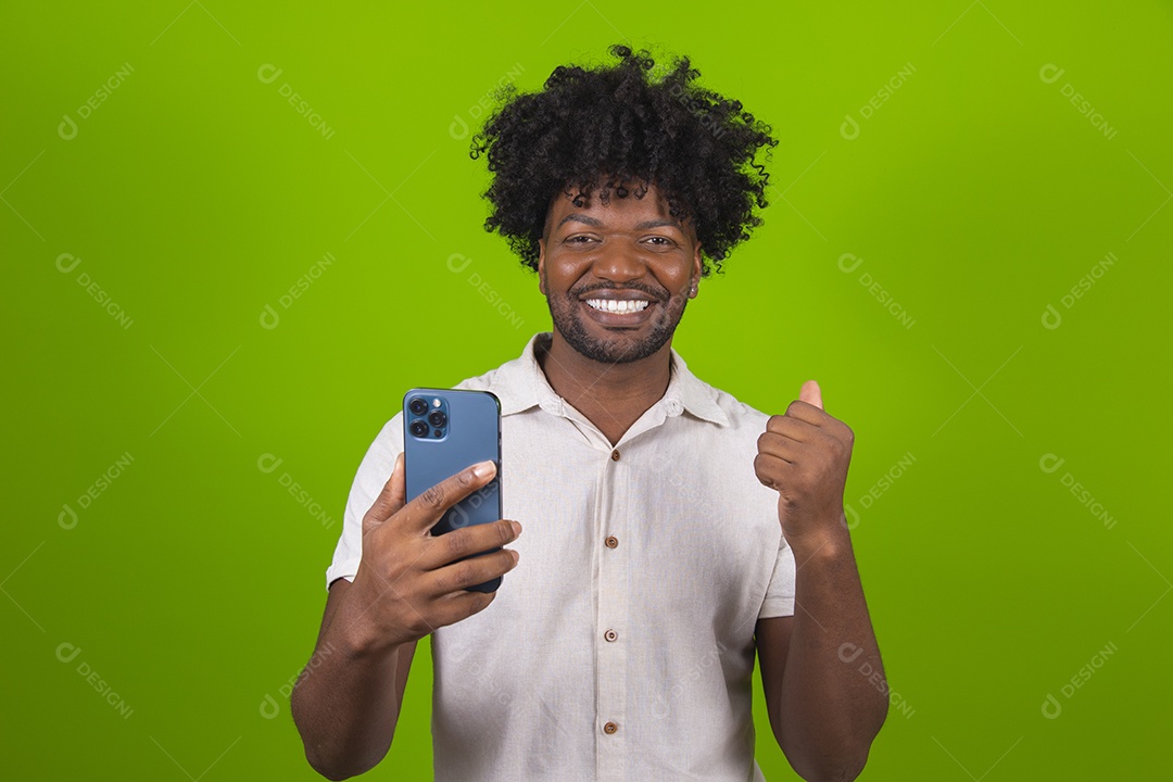 Homem jovem garoto negro segurando smartphone sobre fundo isolado verde