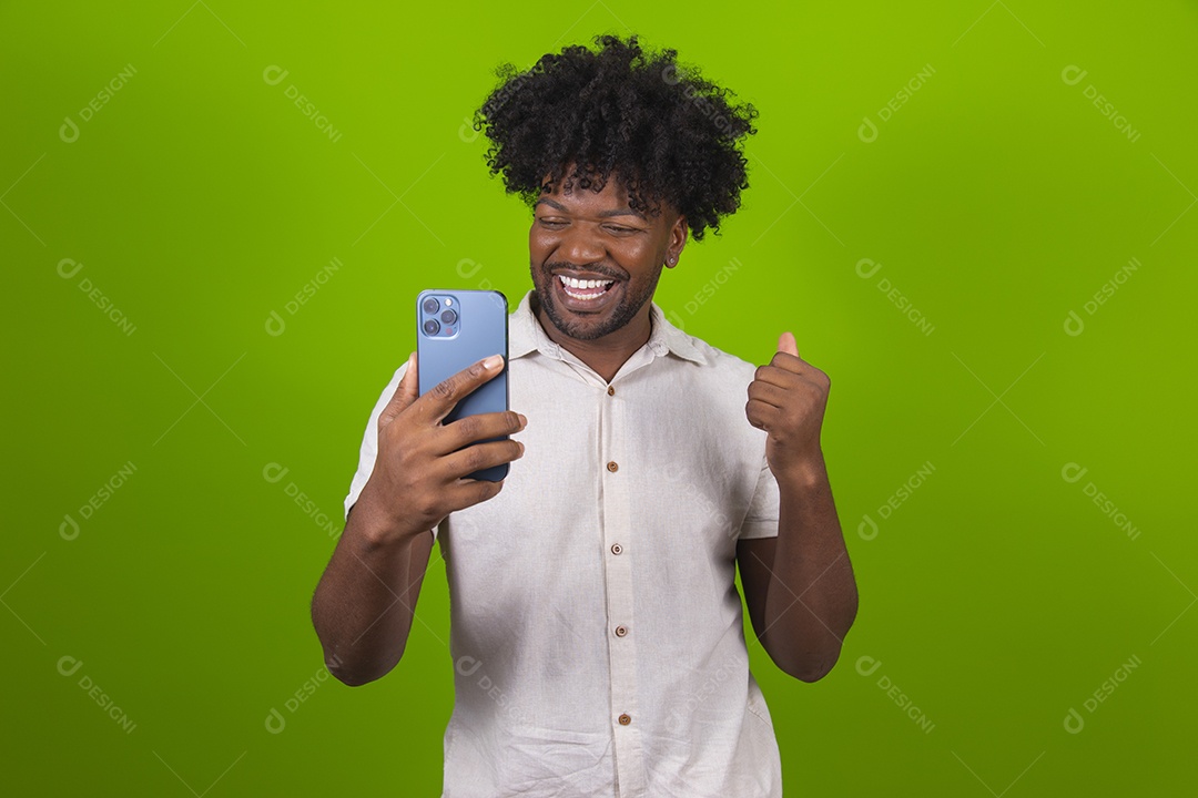 Homem jovem garoto negro segurando smartphone sobre fundo isolado verde