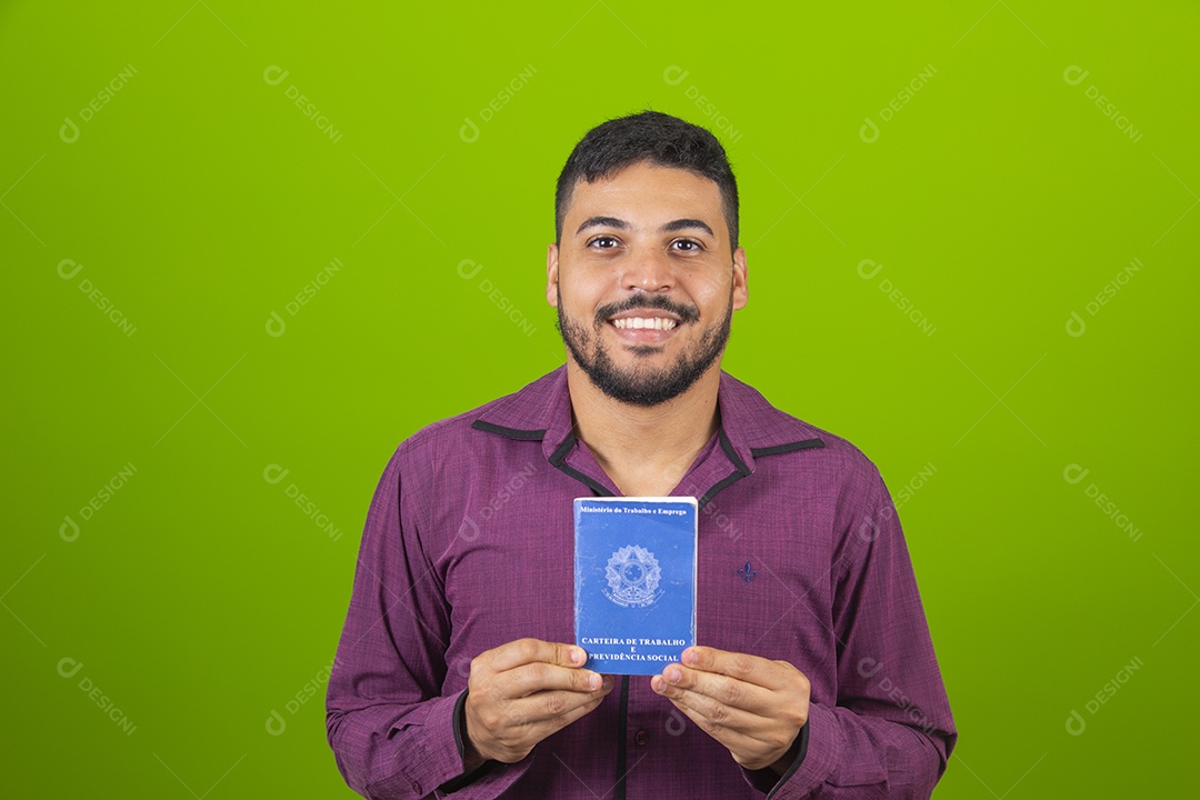 Homem jovem sorridente segurando carteira de trabalho sobre fundo isolado verde
