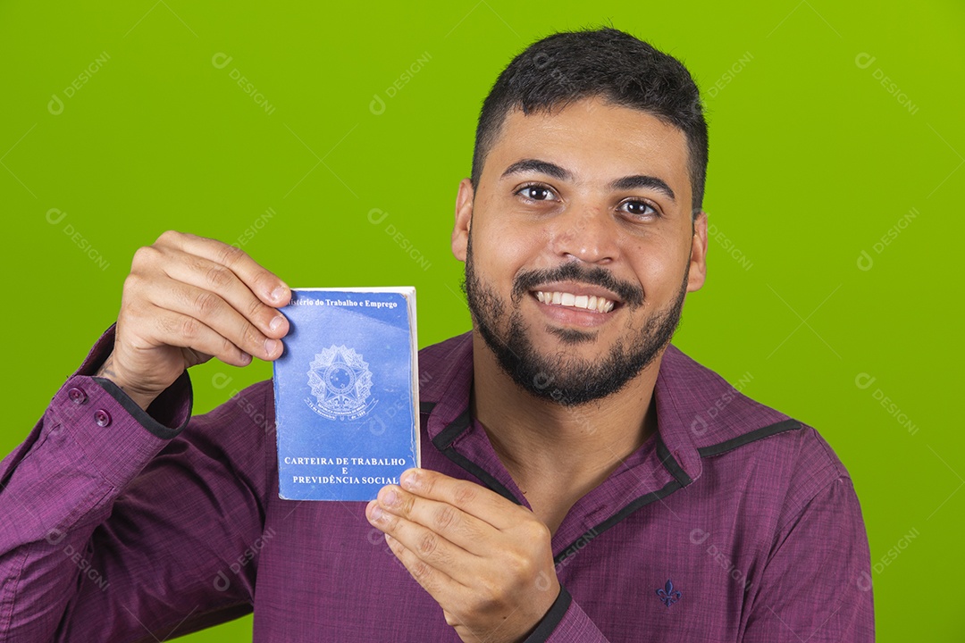 Homem jovem sorridente segurando carteira de trabalho sobre fundo isolado verde