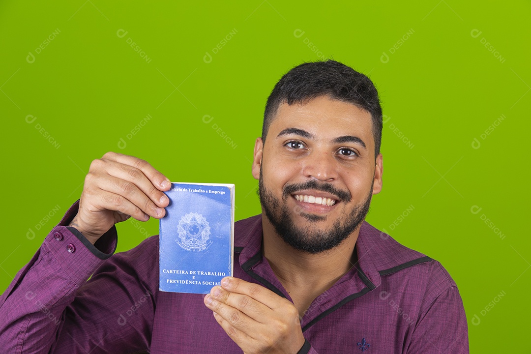 Homem jovem sorridente segurando carteira de trabalho sobre fundo isolado verde