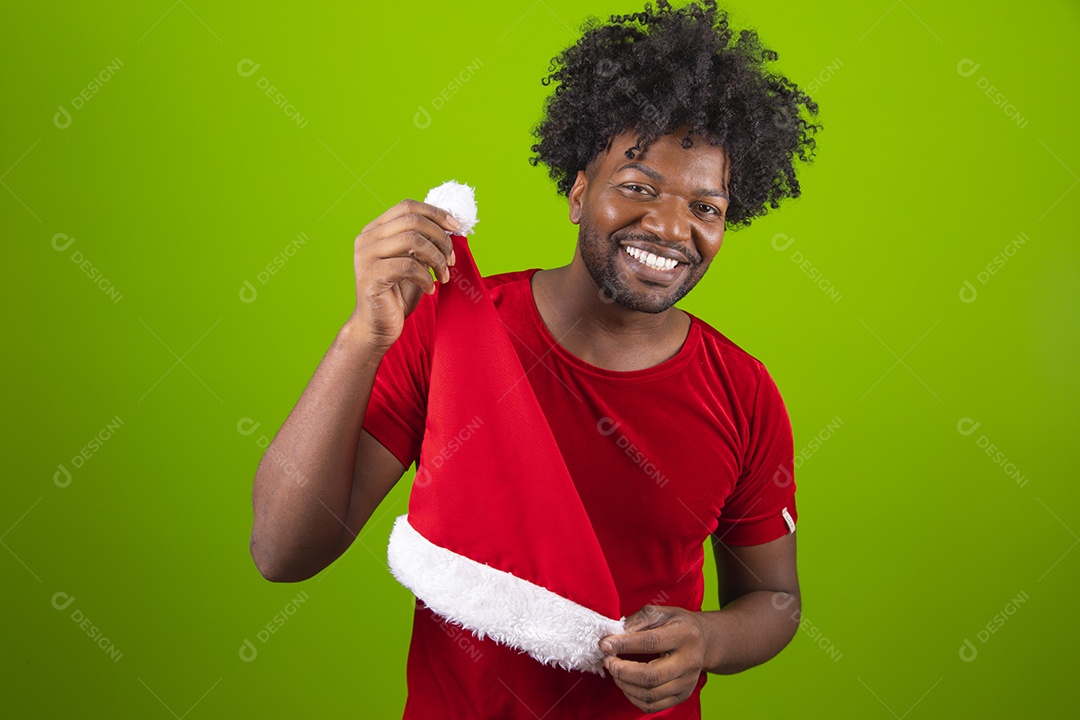 Homem negro jovem comemorando natal feliz e sorridente