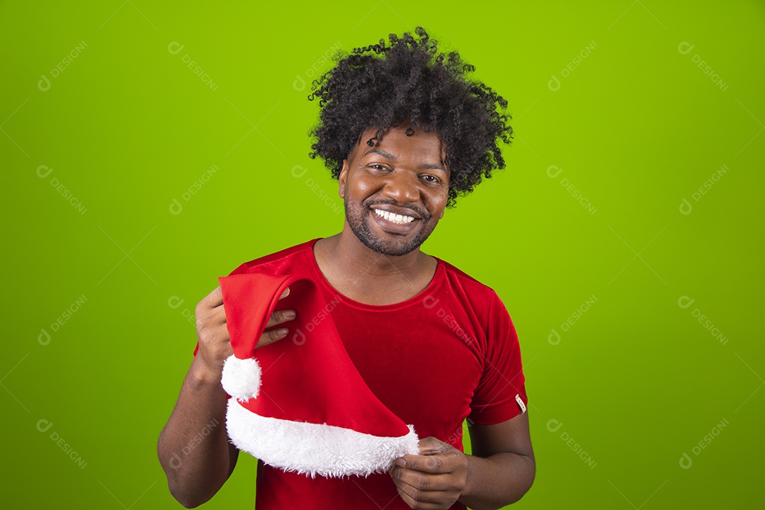 Homem negro jovem comemorando natal feliz e sorridente