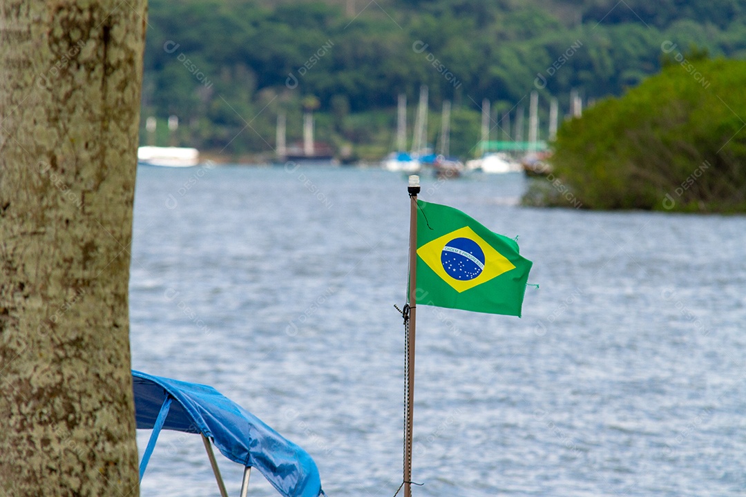 Bandeira do Brasil com o mar ao fundo no Rio de Janeiro.
