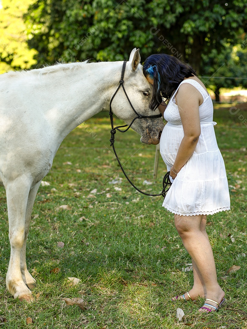 Linda mulher gravida jovem ao lado de seu cavalo fazenda