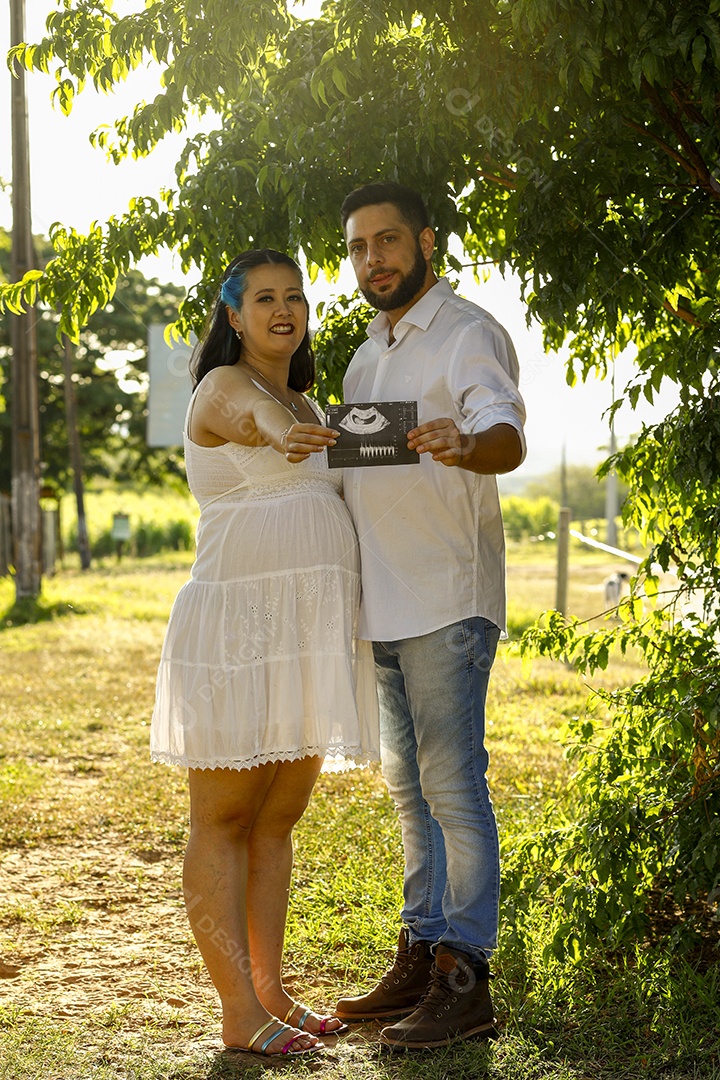 Homem com ao lado de sua esposa gravida sobre um lindo lugar paisagem