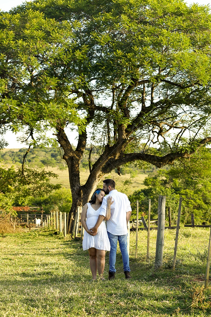 Homem com ao lado de sua esposa gravida sobre um lindo lugar paisagem