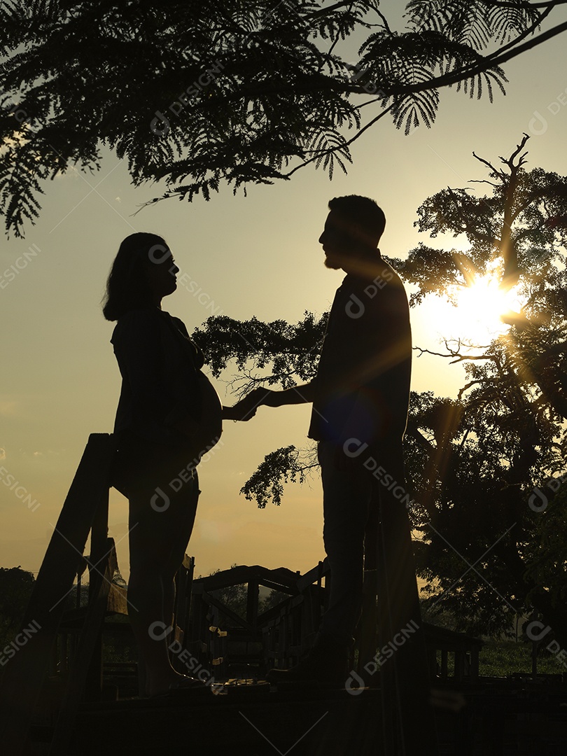 Homem com ao lado de sua esposa gravida sobre um lindo lugar paisagem