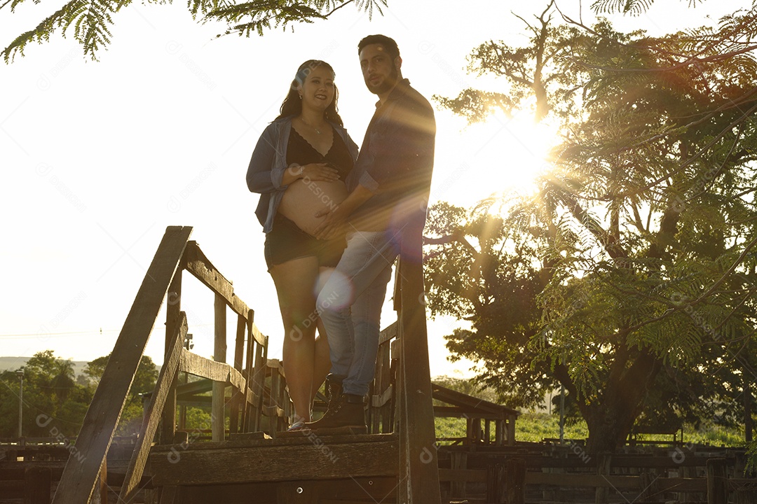 Homem com ao lado de sua esposa gravida sobre um lindo lugar paisagem