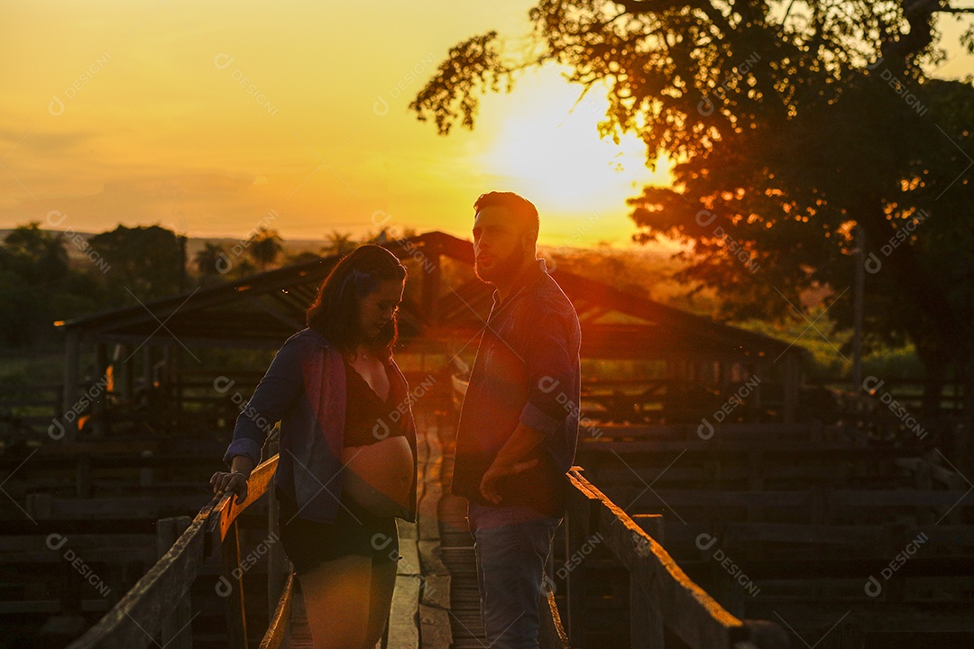 Homem com ao lado de sua esposa gravida sobre um lindo lugar paisagem
