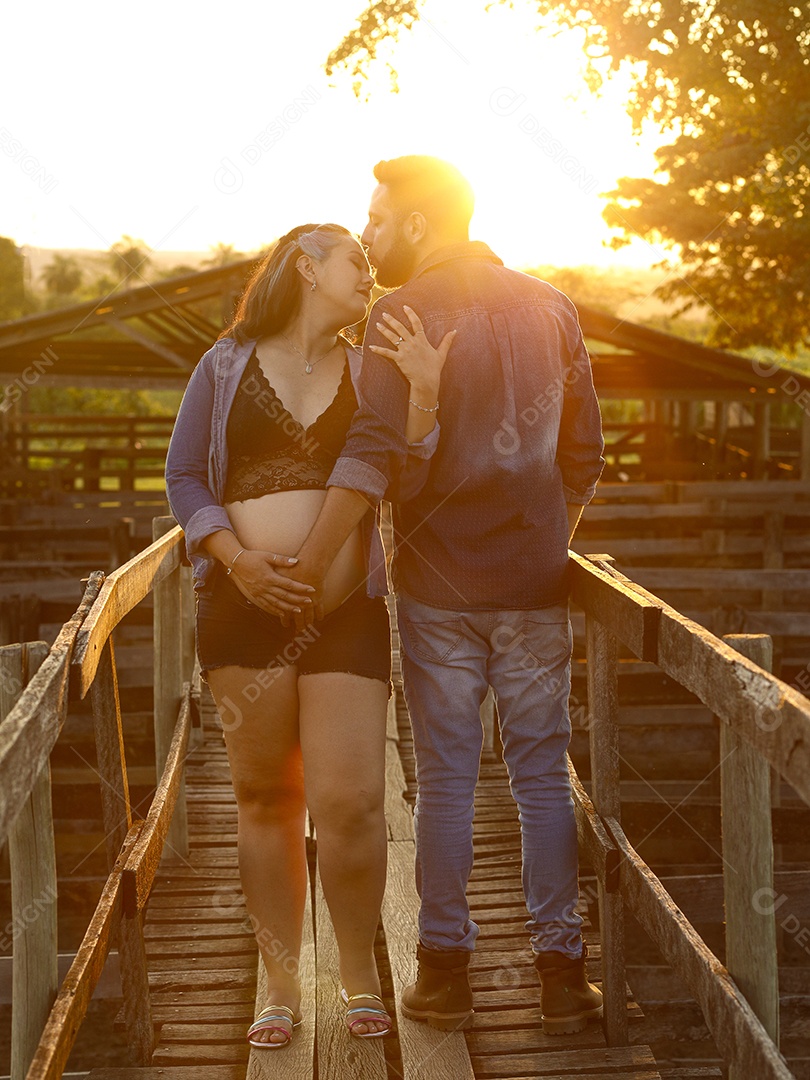 Homem com ao lado de sua esposa gravida sobre um lindo lugar paisagem