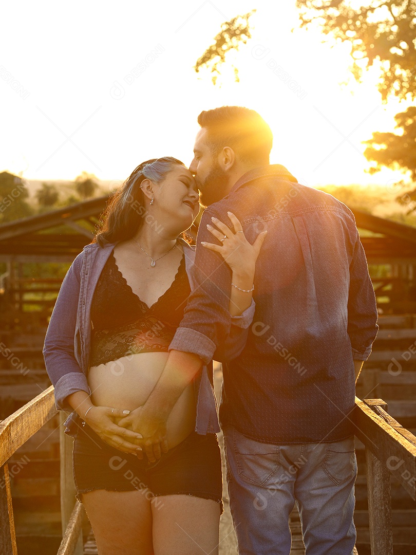 Homem com ao lado de sua esposa gravida sobre um lindo lugar paisagem