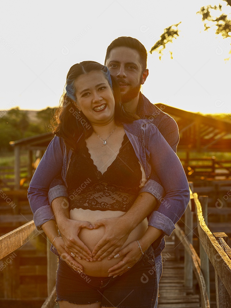 Homem com ao lado de sua esposa gravida sobre um lindo lugar paisagem