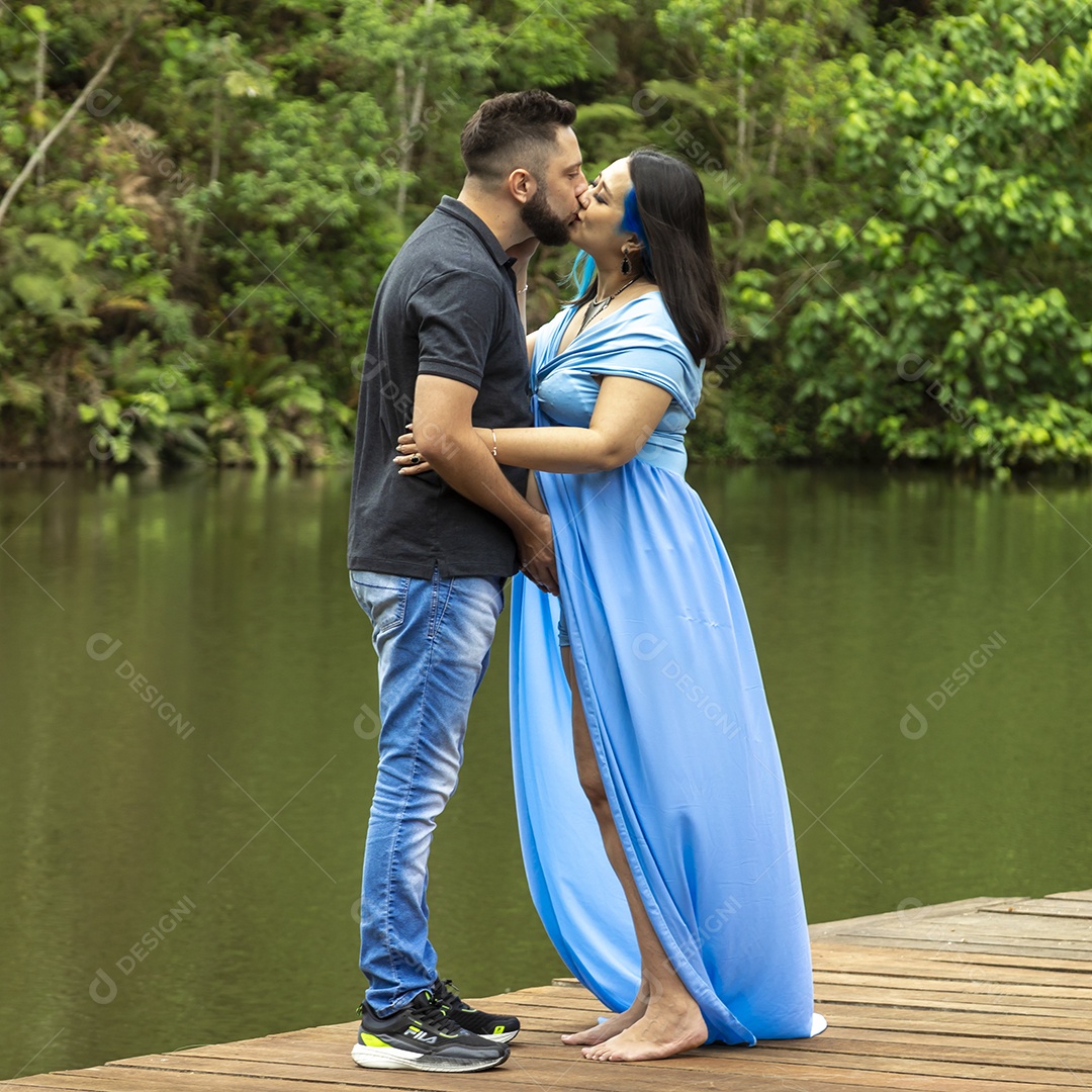 Homem ao lado de sua esposa gravida se acariciando