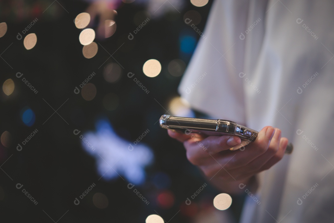 mãos masculinas usando smartphone à noite na cidade com bokeh de fundo