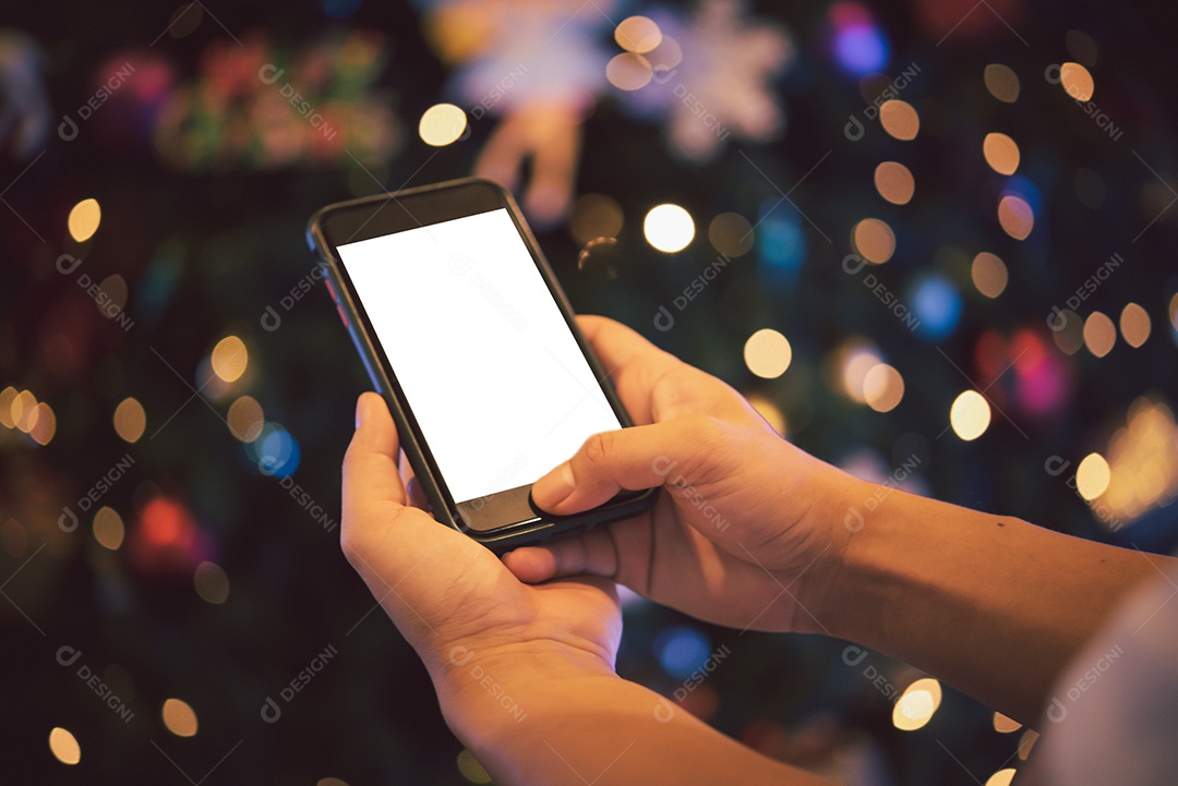 mãos masculinas usando smartphone à noite na cidade com bokeh de fundo