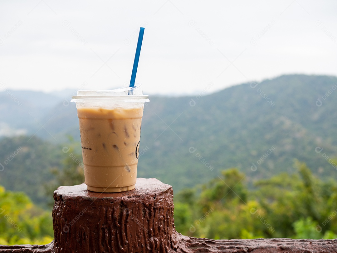 Um copo de café gelado é colocado sobre uma rocha