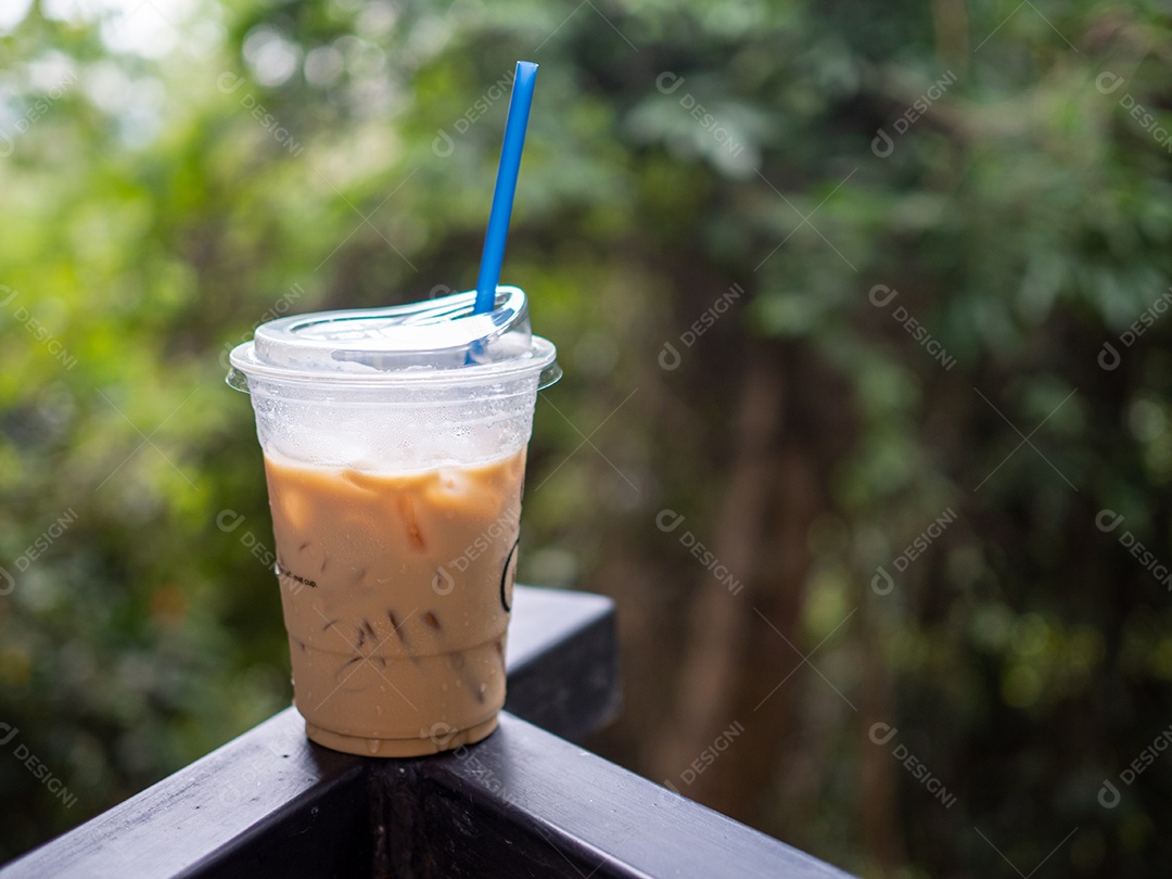 Um copo de café gelado é colocado sobre uma rocha