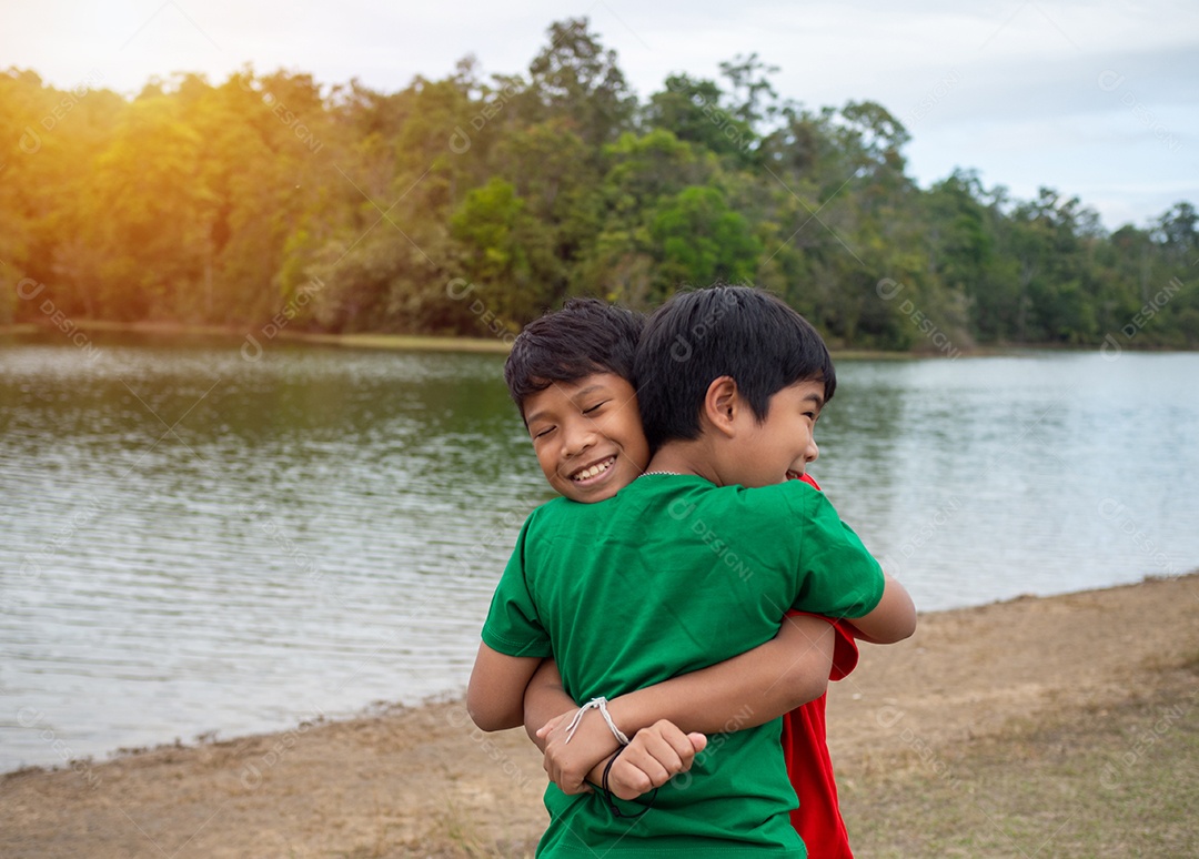 Meninos felizes na beira do rio