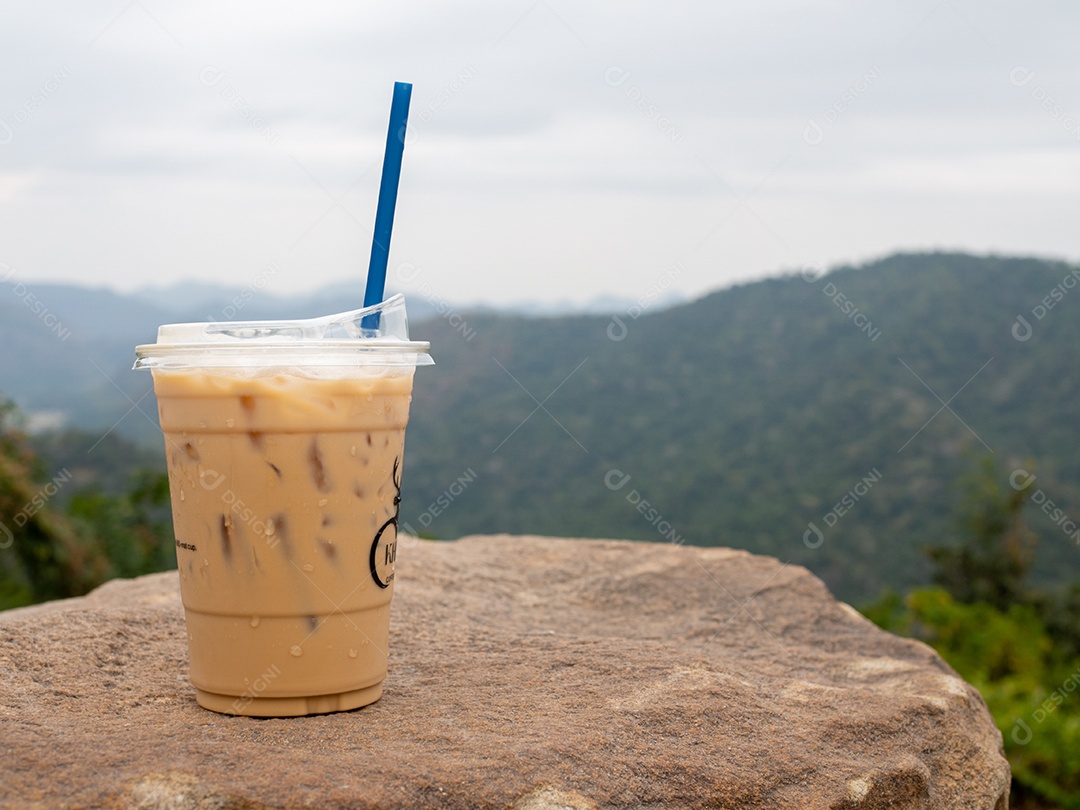 Copo com canudo bebida café gelado com vista de paisagem