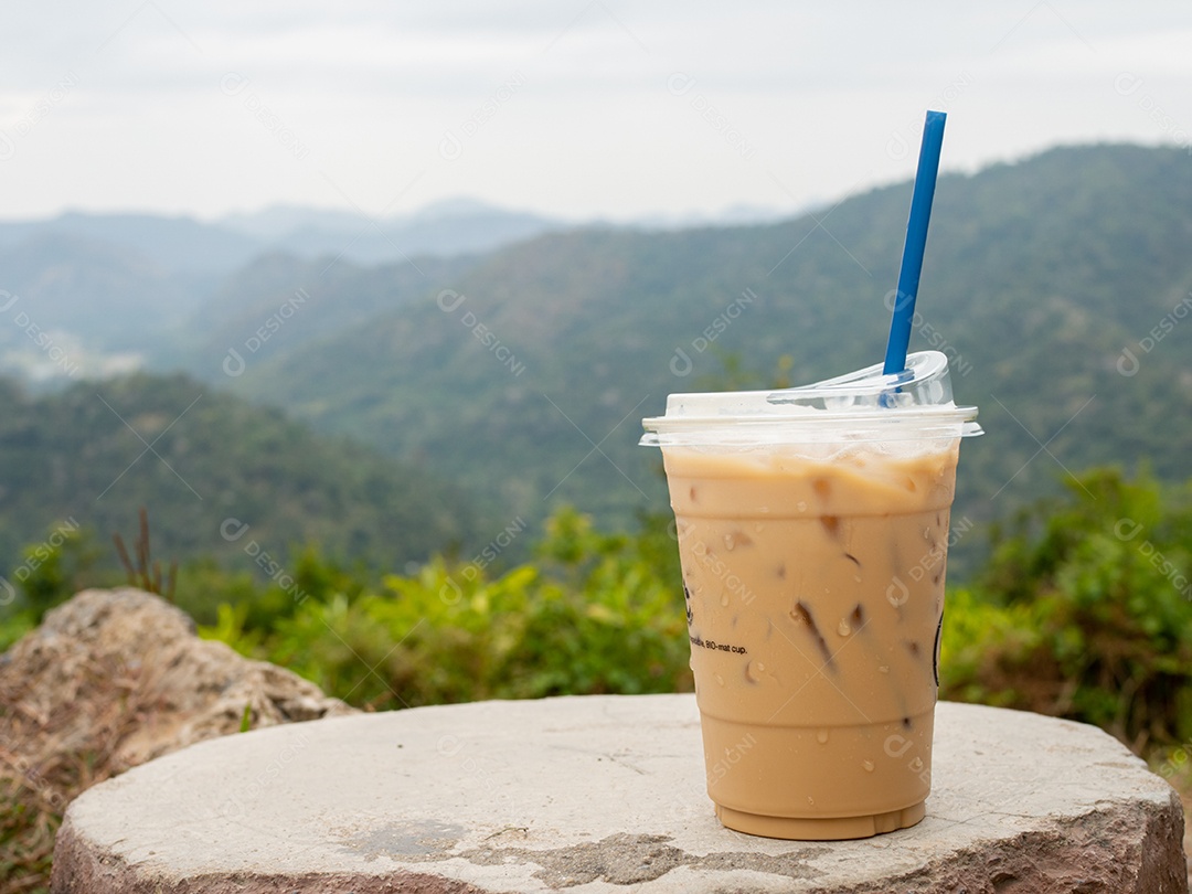 Bebida café gelado sobre madeira com vista de paisagem