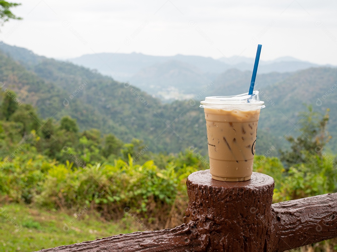 Bebida café gelado sobre madeira com vista de paisagem