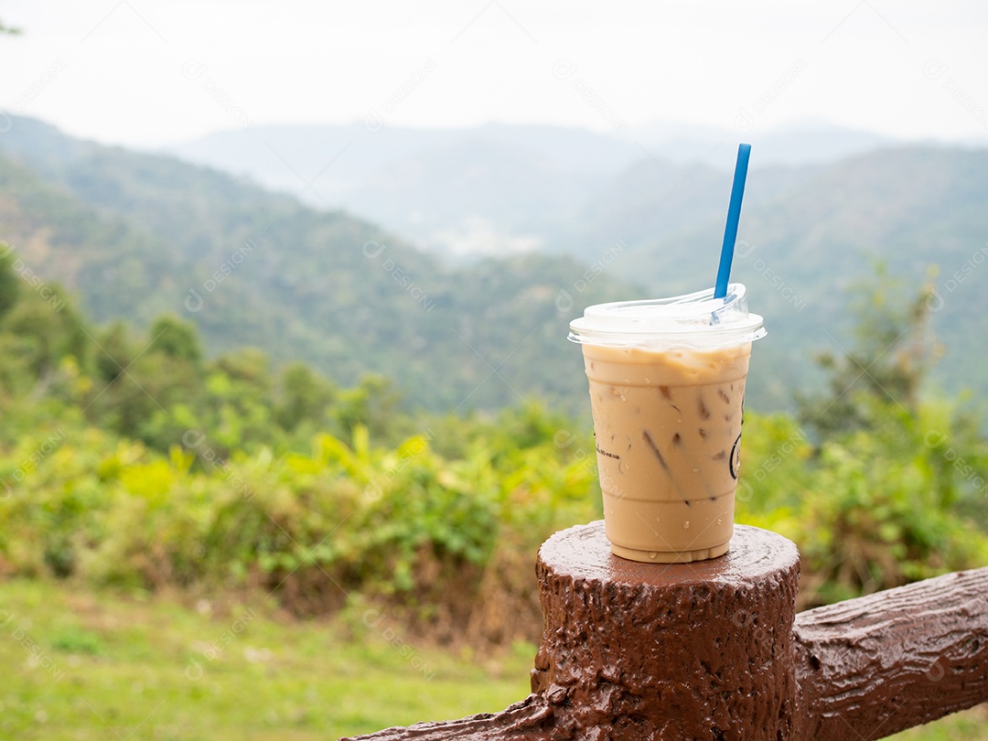 Bebida café gelado sobre madeira com vista de paisagem