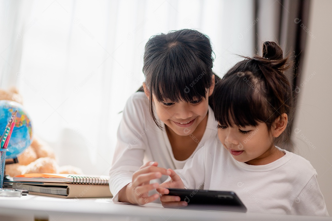 Crianças de conceito e gadgets duas irmãs irmãs olham para o telefone e sorriem