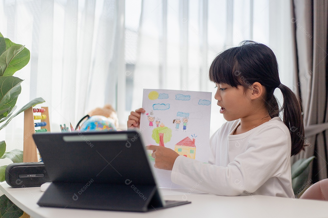 Aluna asiática fazendo sua lição de casa com tablet digital em casa