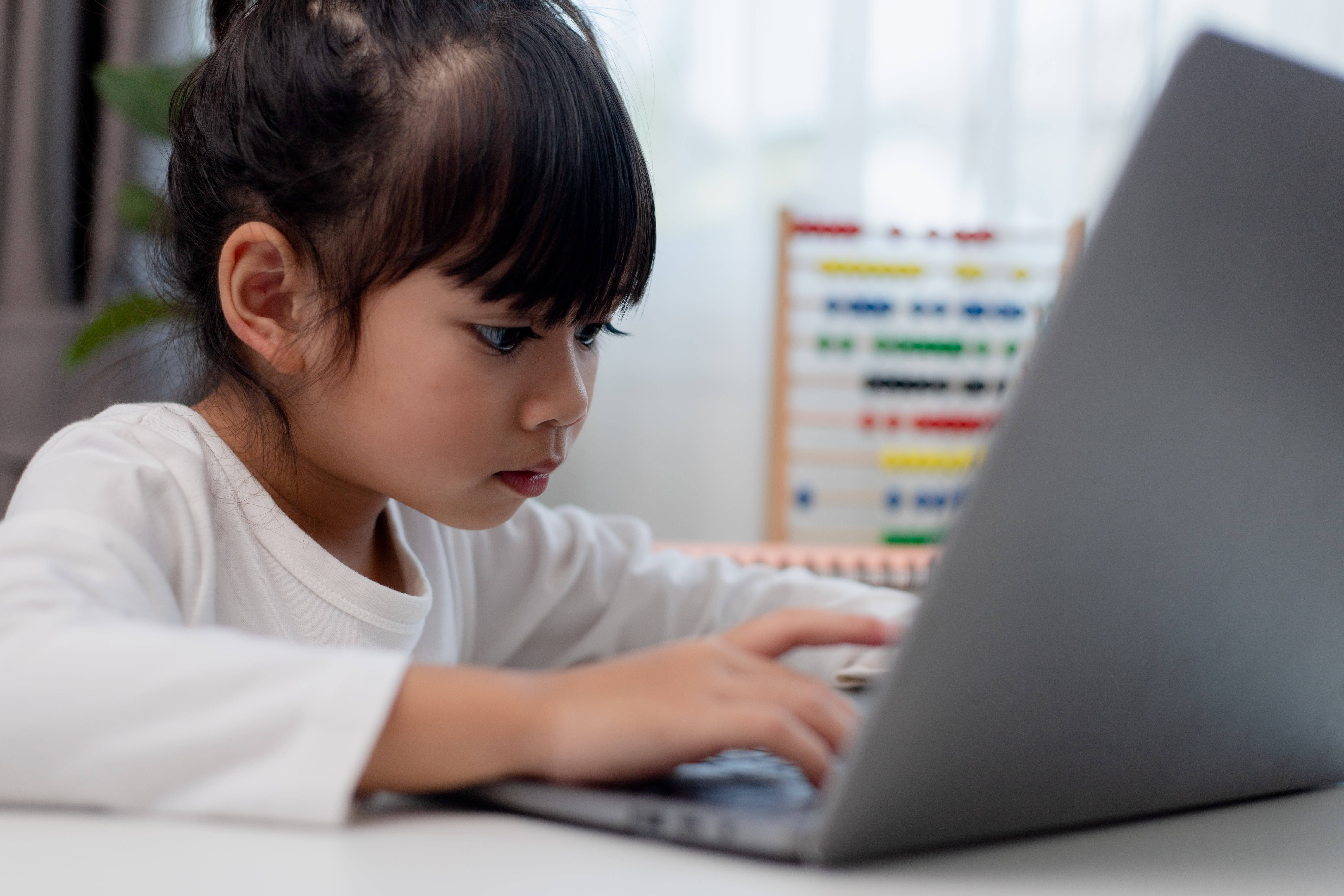 Aluna asiática fazendo sua lição de casa com tablet digital em casa