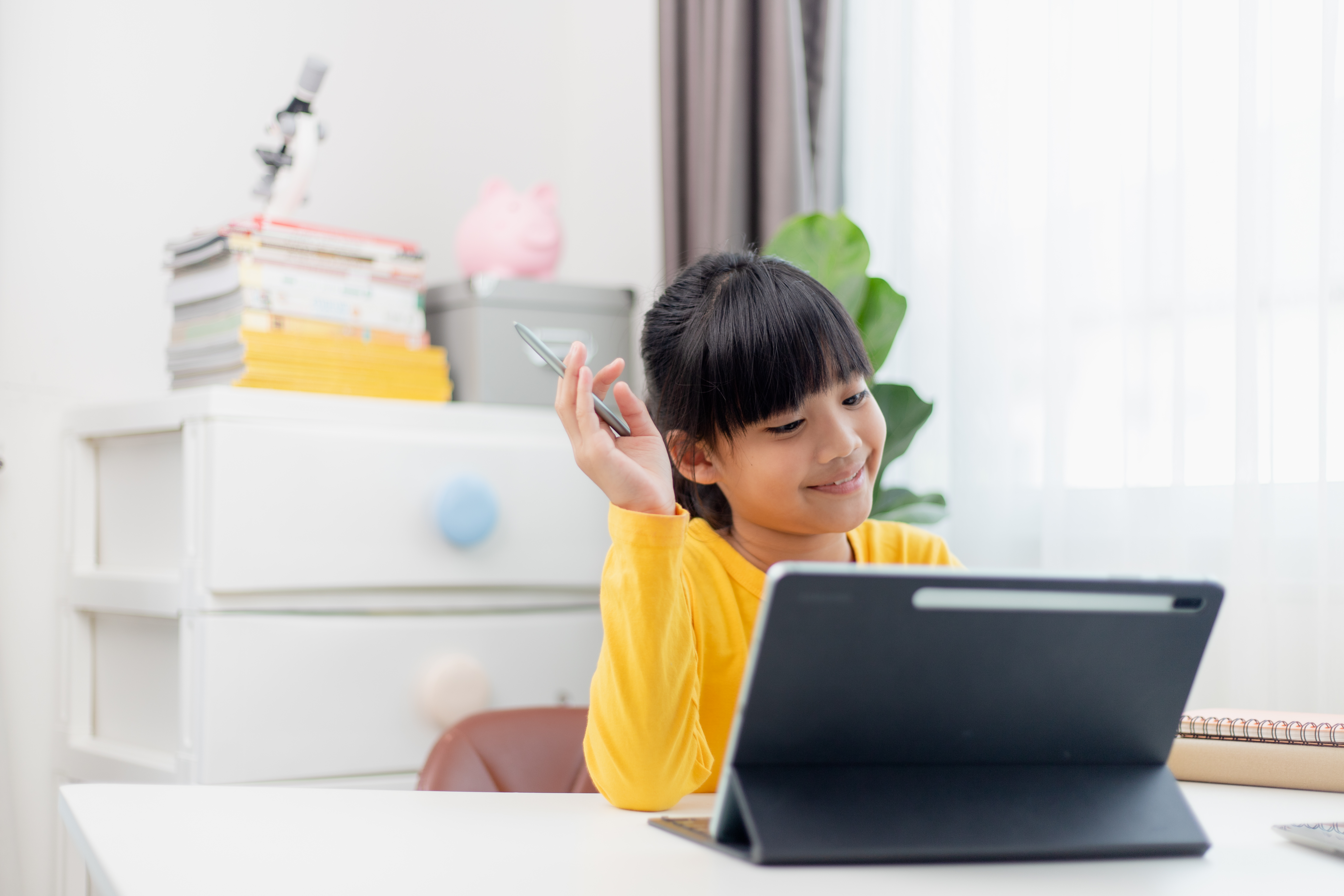 Aluna asiática fazendo sua lição de casa com tablet digital em casa