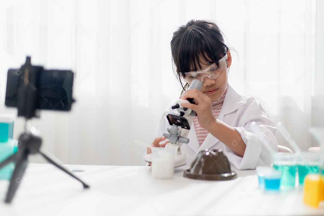 Menina da escola asiática fazendo experimentos de química fáceis e gravando