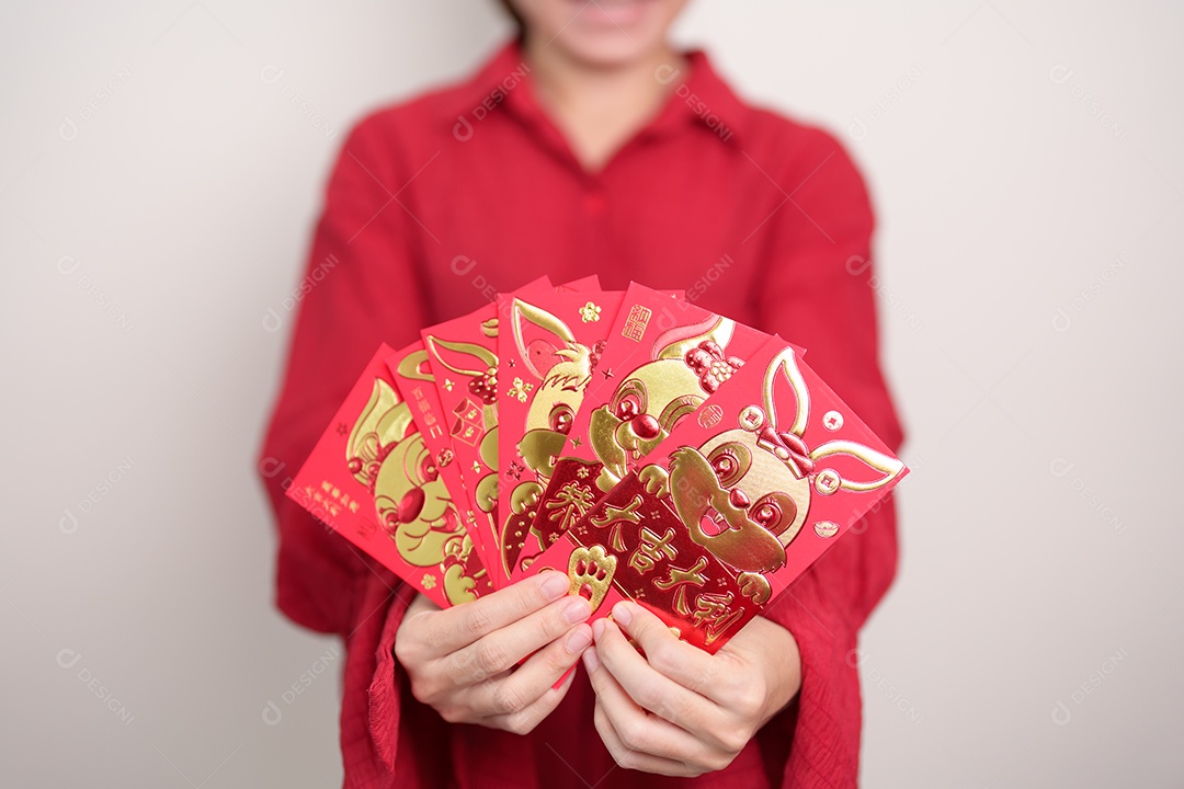 Mulher segurando envelope vermelho chinês com coelho dourado