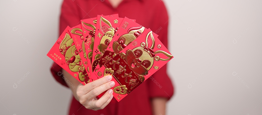 Mulher segurando envelope vermelho chinês com coelho dourado