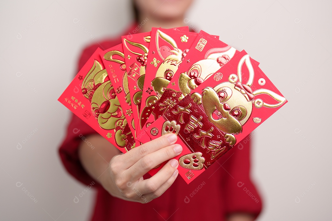 Mulher segurando envelope vermelho chinês com coelho dourado